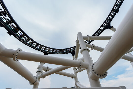 Attraction roller-coaster with the background of the cloudy sky.