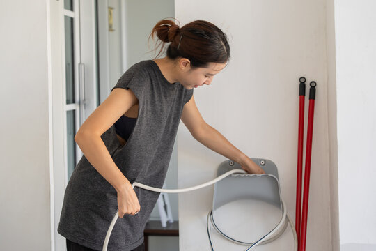 Woman keep a hose and a hose reel after work.