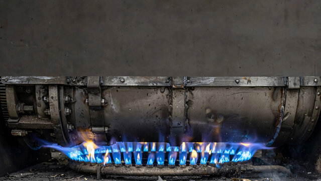 A close-up shot showcases the vibrant blue flames of a gas stove burner igniting, emitting warmth and a sense of domestic utility.