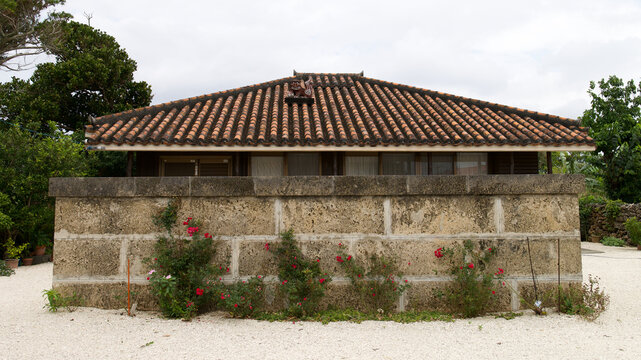 Traditional red tiled roof house with a shisa statue in Taketomi island