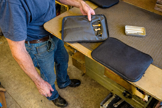 Repair Shop Owner Inspecting Parts in a Fabric Pouch