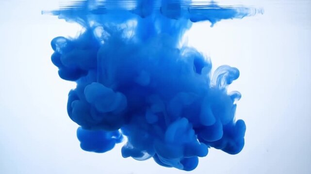 Blue ink clouds dispersing in clear water against white background