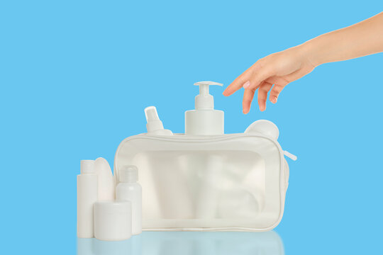Cosmetics. User selects travel cosmetics from neatly arranged toiletry bag. Convenience concept
