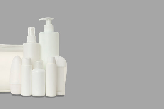 Cosmetics. Arranged white cosmetic containers next to a stylish toilet bag