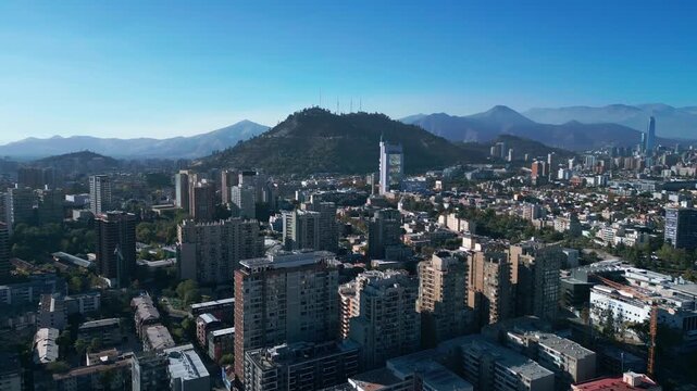 Aerial view of Santiago city skyline and Cerro San Cristobal with urban buildings and mountains under a clear blue sky in Santiago, Santiago Metropolitan, Chile.