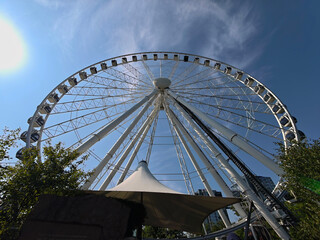 Low angle view of a giant white ferris wheel against a bright blue sky © IMRAN_IM33