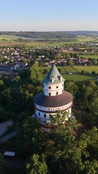 Aerial view of the historic Humprecht hunting lodge with its distinctive circular architecture and green roof, set amidst lush trees in Sobotka, Kralovehradecky kraj, Czechia.