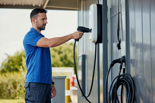 Technician Inspecting Electric Vehicle Charging Station Equipment