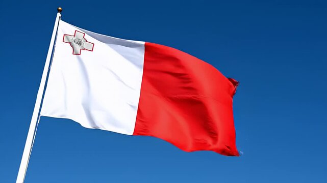 The Maltese flag waving in the wind against a clear blue sky, representing national pride and travel.