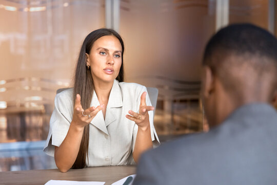 Businesswoman conducting office meeting with corporate client or male colleague, presenting decision, sharing project updates, providing business information. Professional communication, negotiations