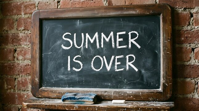 Chalkboard with the text summer is over written in white chalk against a rustic brick wall background