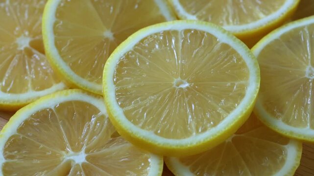 Yellow lemon slices piled togather, close shot. Rotative background. 