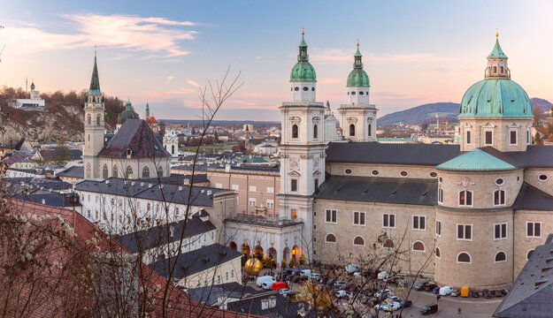 Elevated view of Salzburg Cathedral and surrounding historic architecture in the city center at sunset, Austria.