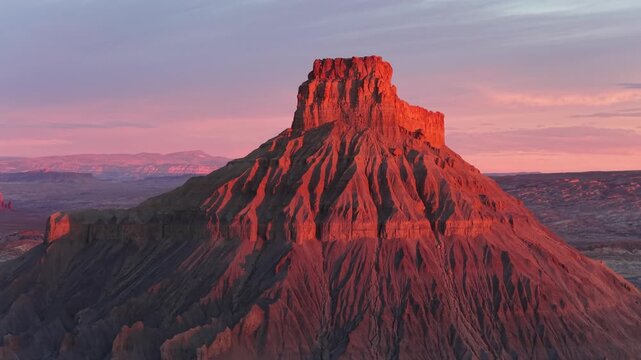 Aerial view of Factory Butte with dramatic eroded badlands and golden hour light in Wayne County, Utah, United States.