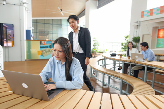 Young Asian Businesswoman Working on Laptop in Modern Outdoor Office Space