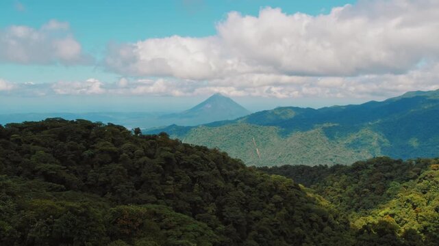 Green mountain forest view with distant volcano Arenal in Costa Rica