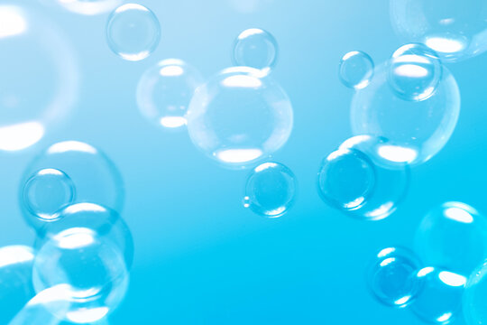 Clear Soap Bubbles on Blue Background. Freshness Soap Suds Bubbles Water. Celebration Festive Backdrop. Blue Gradient Blurred Background. 