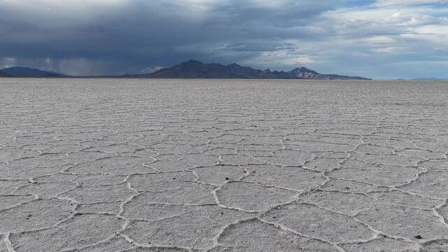 Aerial view of the vast salt crust patterns at Bonneville Salt Flats under a dramatic stormy sky in Tooele County, Utah, United States.