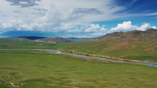Aerial view of Orkhon Valley Natural and Historical Reserve with winding river, vast green grasslands, and scattered gers in Xarxorin, Ovorkhangai, Mongolia.