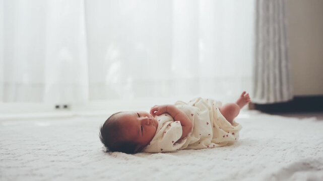 白い部屋で寝転がる赤ちゃん