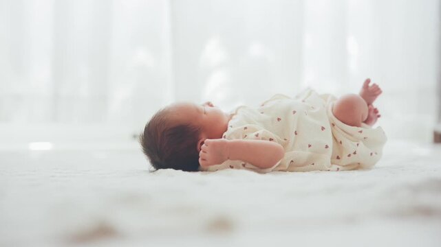 白い部屋で寝転がる赤ちゃん