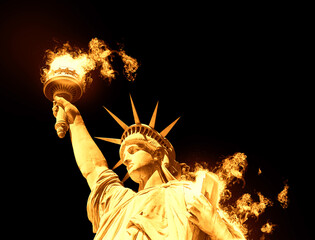  Statue of Liberty with burning fire isolated on black background © Maria