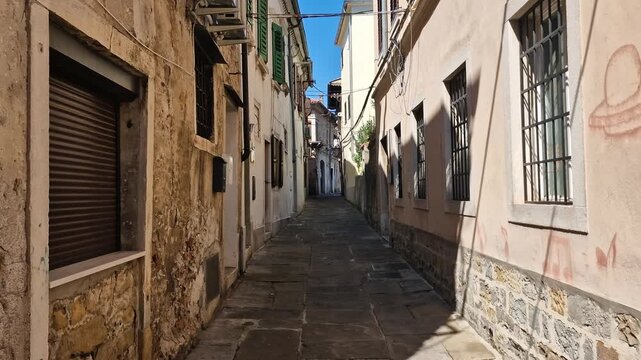 Narrow Street and Buildings in Old Town of Koper, Slovenia. Facades and Pavement on Hot Summer Day
