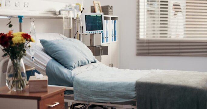 Empty, hospital and bed in ward for medical, admission and inpatient care for surgery treatment. Interior, icu room and flowers in facility with furniture, vital signs machine and healthcare services