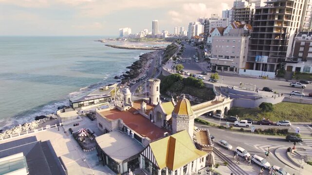 4K drone aerial view of Torre&oacute;n del Monje in Mar del Plata, Argentina. The iconic coastal landmark stands above the Atlantic waterfront with the city&rsquo;s urban skyline stretching behind it.