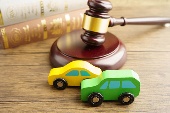 Car accident lawsuit and insurance, Judge hammer with car model.