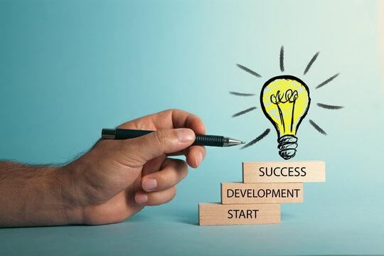 Businessman hand drawing light bulbs on wooden stairs for creative idea and growth process concept