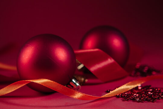 Red christmas balls and ribbons on a red background with copy space