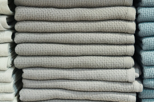 Neatly folded stack of light gray waffle weave towels for contemporary home interior decor