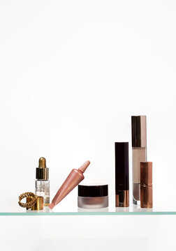 Assortment of cosmetic products with metallic packaging including cream, foundation, lipstick, and serum, representing beauty, elegance, and self-care.