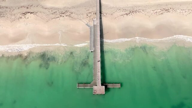 Aerial view of Coogee Jetty extending into the turquoise waters of the Indian Ocean at Coogee Beach, Coogee, Western Australia, Australia.