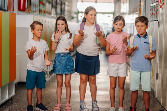 Group of diverse students having fun in school hallway