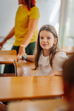 Schoolgirl smiling in classroom during lesson