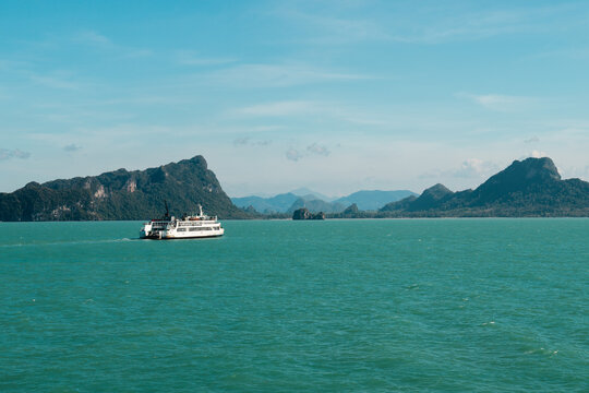 Passenger Ferry Crossing Turquoise Sea Below Rugged Mountain Islands