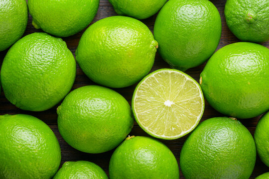 Top view of fresh ripe limes. Bright green background