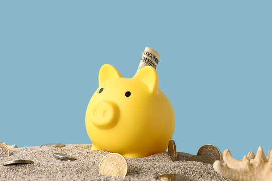 Vacation savings and travel budget, yellow piggy bank with dollar bill in sand on beach for summer holiday financial planning and retirement fund