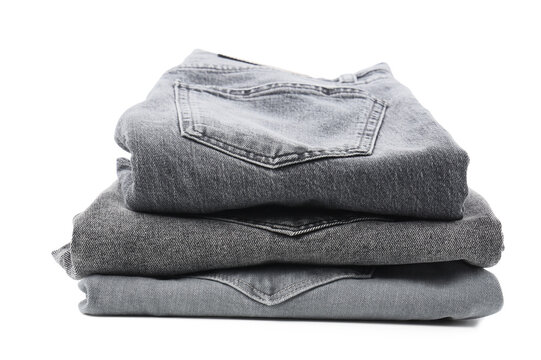 Sustainable fashion and clothing consumption, stack of folded grey denim jeans for retail or laundry concept isolated on a white background