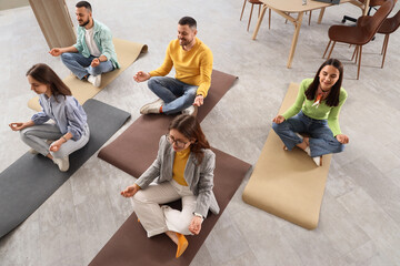 Workplace wellness and stress management, diverse employees practicing meditation and mindfulness...