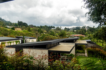 Naklejka premium Modern house on a lush hillside under cloudy skies