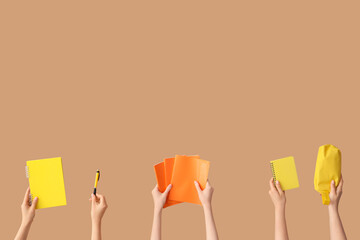 Female hands with set of school equipment on beige background