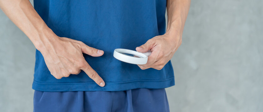 Man uses magnifying glass for size problems, discomfort from disease and inflammation. Venereal, testicular cancer. bladder problems, erectile dysfunction, premature ejaculation, prostate cancer.