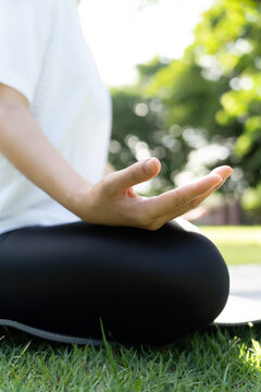 woman practicing meditate on the park. Asian woman doing exercises in morning. balance, recreation, relaxation, calm, good health, happy, relax, healthy lifestyle, reduce stress, peaceful, Attitude.