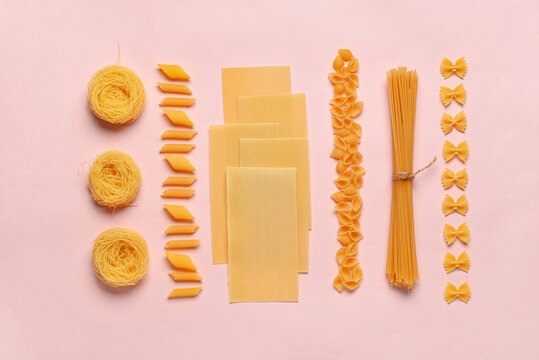 Composition with different tasty uncooked pasta on pink background