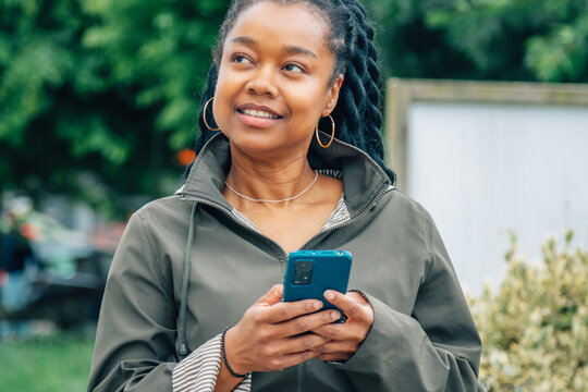 black woman with phone on the street