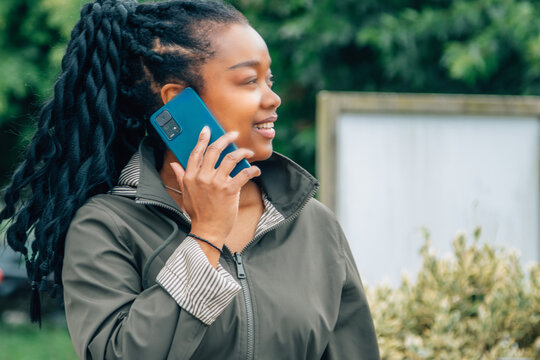 black woman with phone on the street