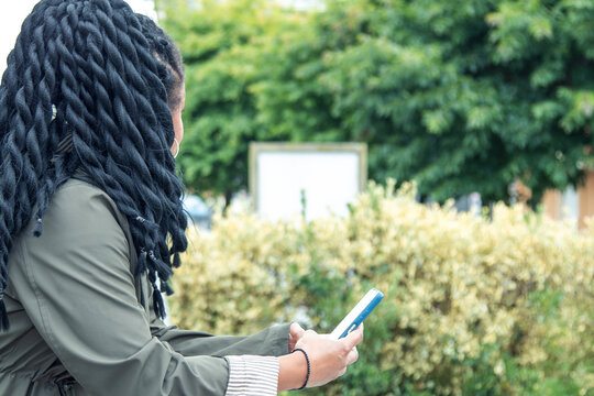 black woman with phone on the street